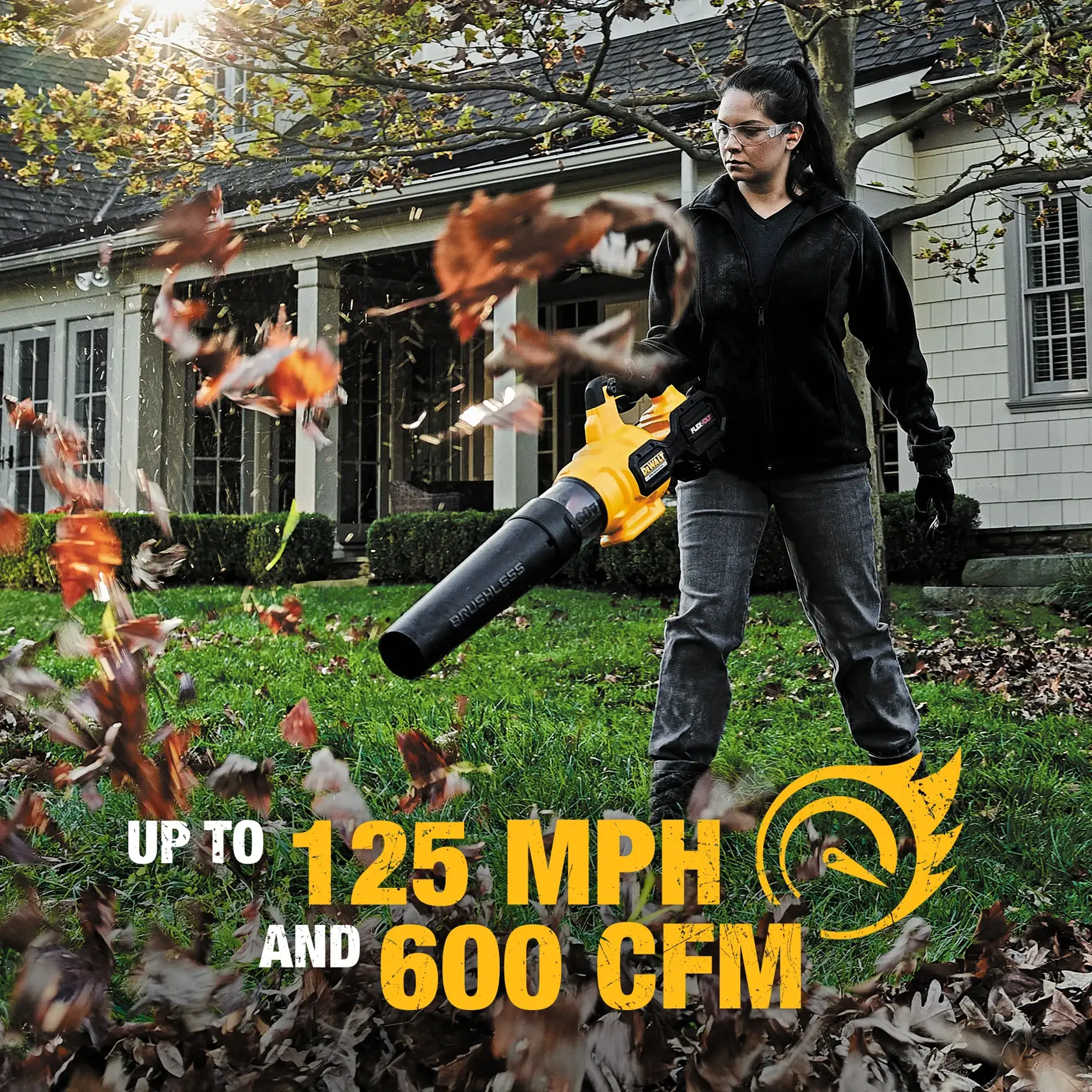 Low angle view of  FLEXVOLT Brushless Cordless Handheld Axial Blower being used to clear away grass blades