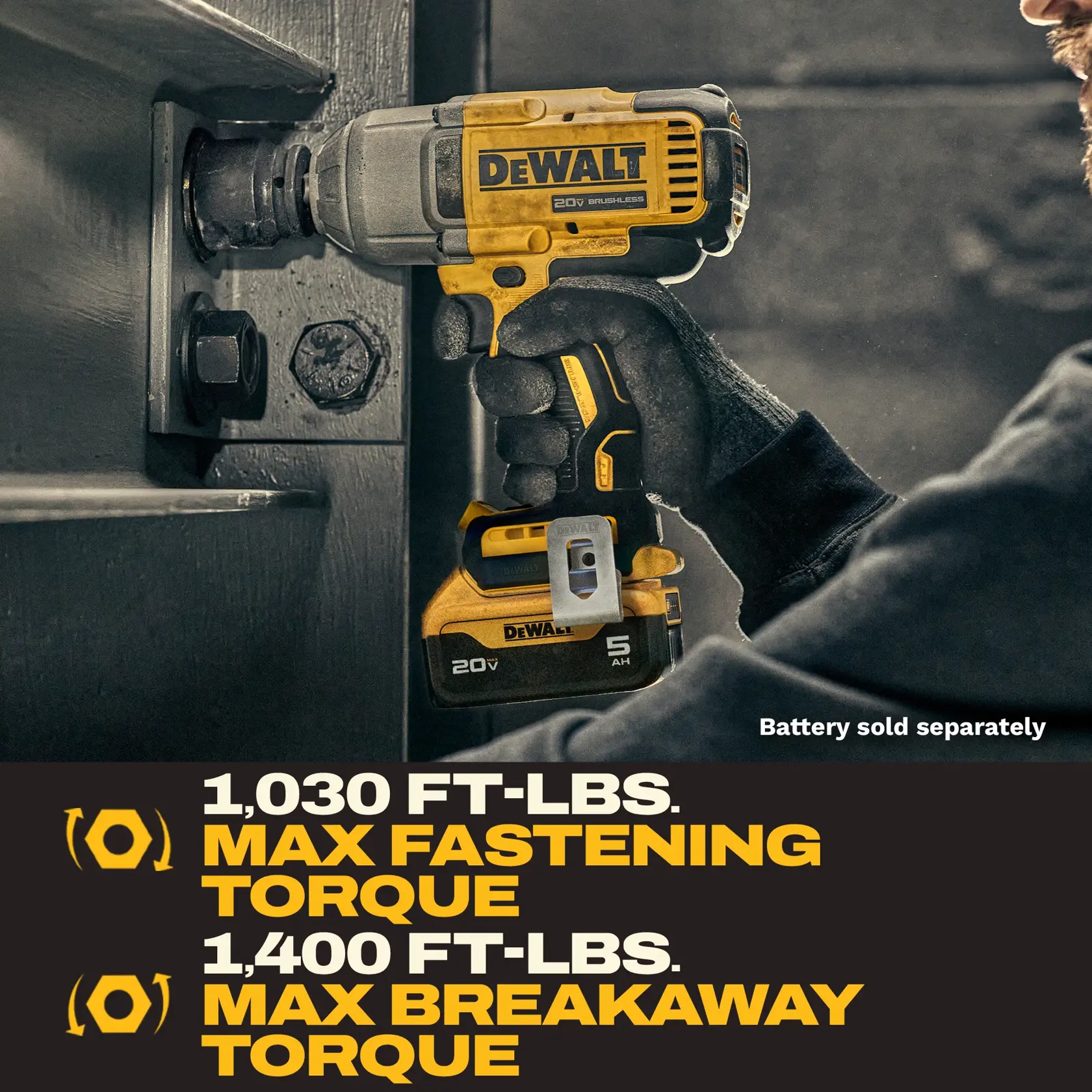 A person is using a yellow and black DeWalt 20V cordless impact wrench to fasten a large bolt on an industrial metal structure. The tool is advertised with a maximum fastening torque of 1,030 ft-lbs and a maximum breakaway torque of 1,400 ft-lbs. The battery for the tool is sold separately.