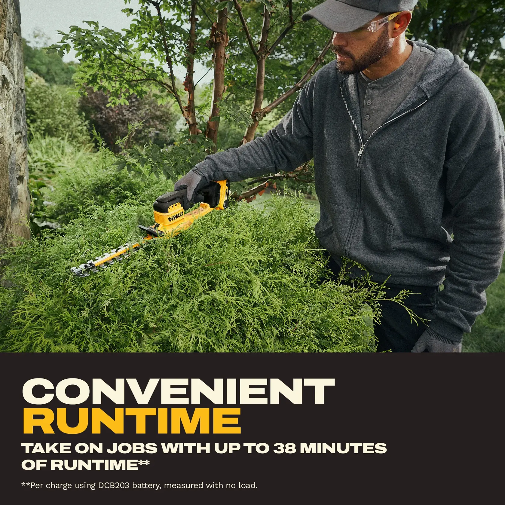 A person wearing a gray hoodie and gloves trims green bushes outdoors using a yellow DEWALT cordless hedge trimmer. Promotional text below highlights convenient runtime, stating jobs can be taken on with up to 38 minutes of runtime per charge with a DCB203 battery, measured with no load.