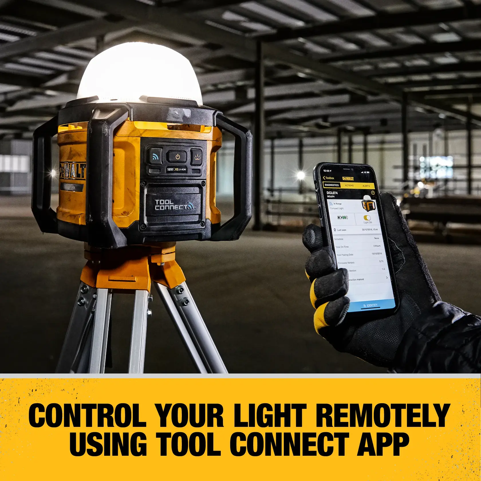 A DEWALT portable LED work light mounted on a tripod, illuminating a large, unfinished concrete indoor space.