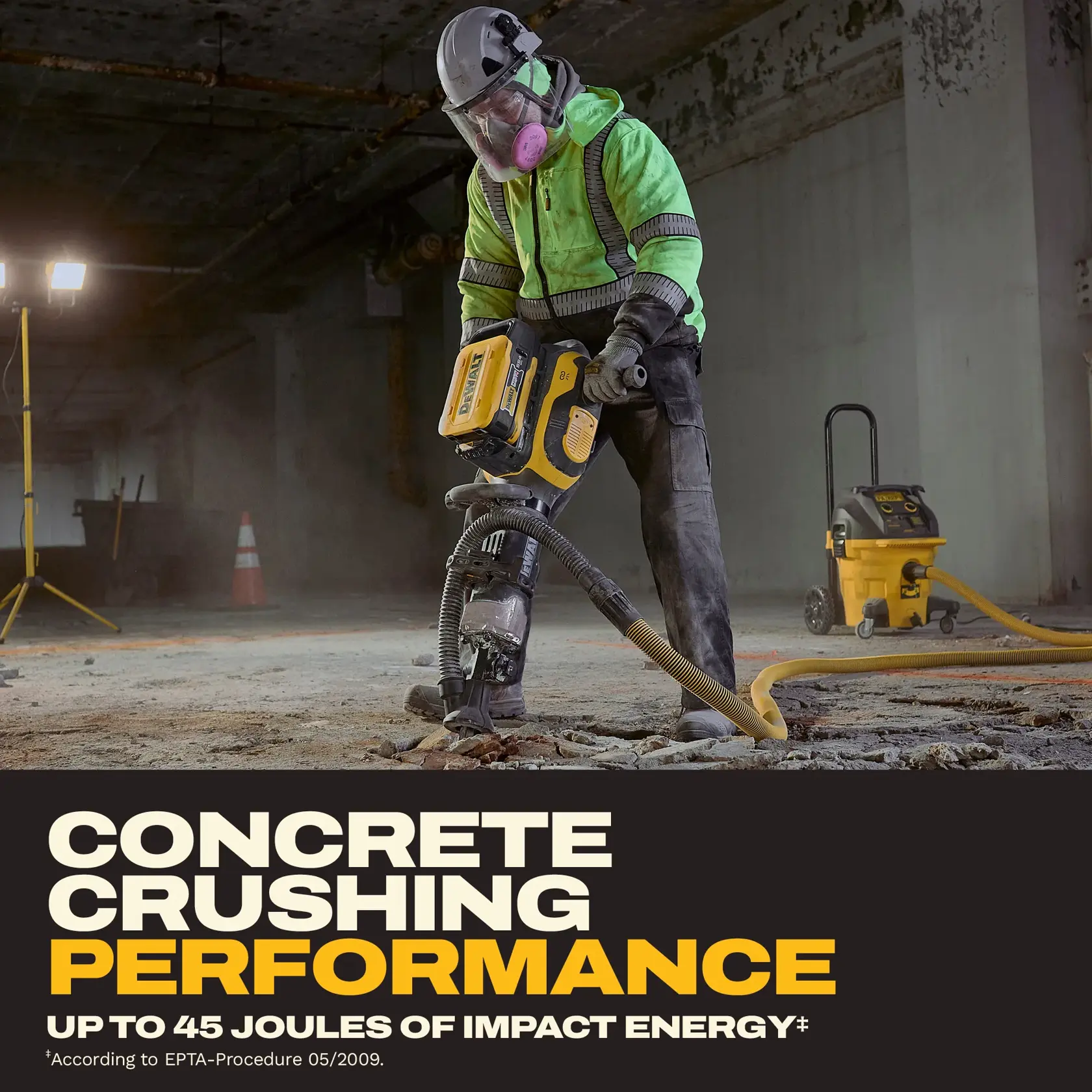 A construction worker wearing safety gear uses a DEWALT demolition tool to crush concrete indoors. The worker is equipped with a helmet, face shield, and a high-visibility jacket. Yellow DEWALT equipment is visible, including a dust extractor connected to the tool. The scene is lit with construction lights, and the image highlights the tool’s performance with up to 45 joules of impact energy.