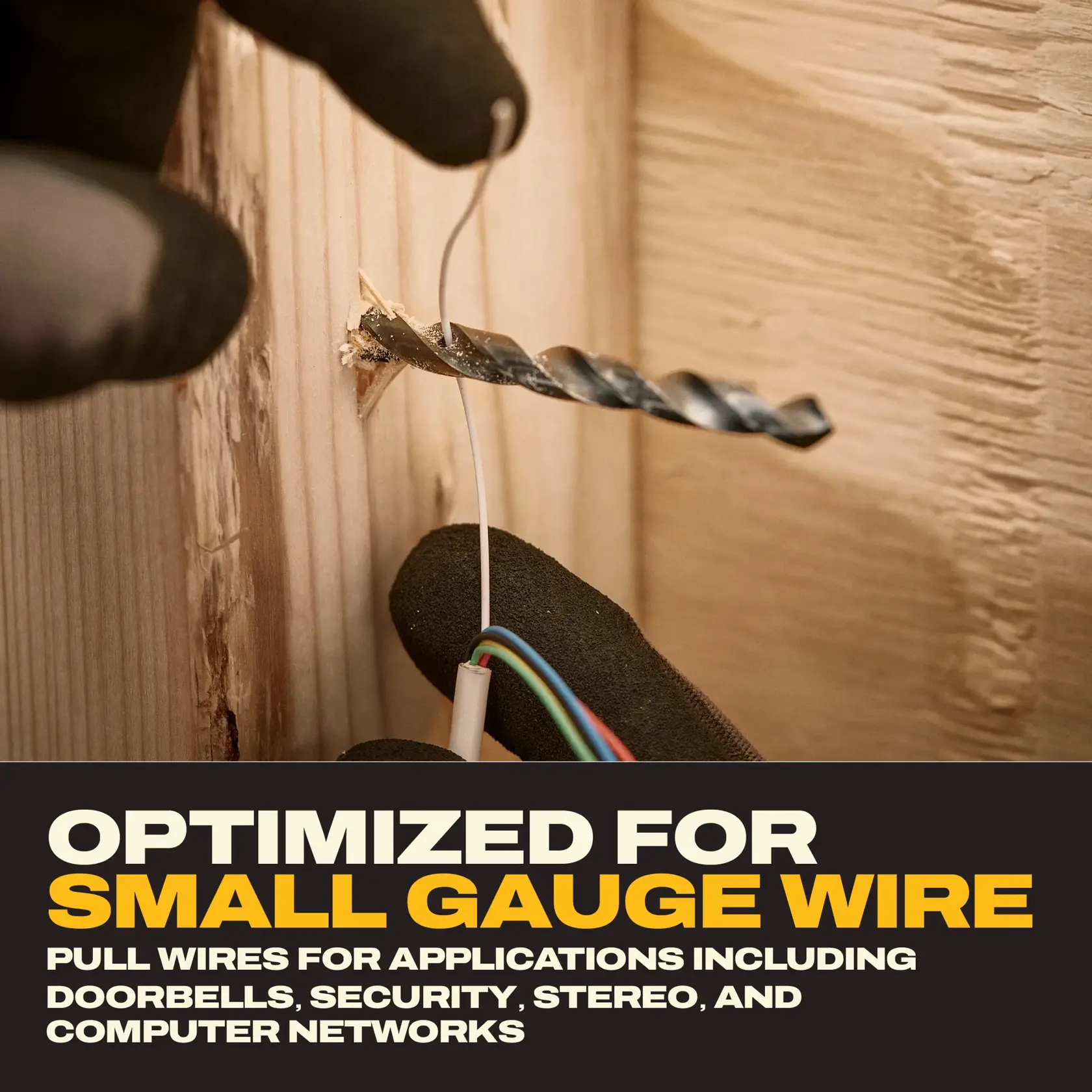 A close-up of gloved hands pulling small gauge wire through a hole drilled in wood using a drill bit. Text below reads: 'Optimized for small gauge wire. Pull wires for applications including doorbells, security, stereo, and computer networks.'