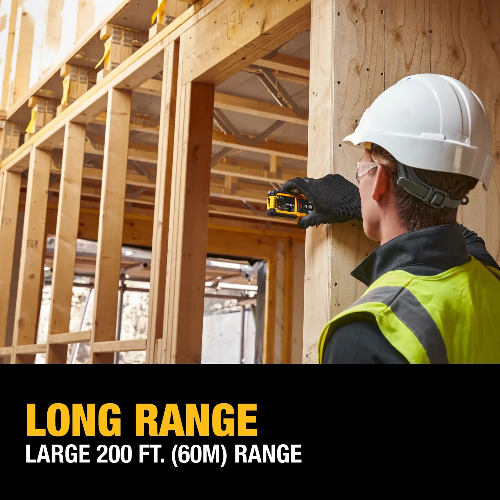 A construction worker wearing a white hard hat, safety glasses, and a high-visibility vest uses a DEWALT laser distance measurer to measure a wooden frame structure. The text overlay reads: LONG RANGE. LARGE 200 FT. (60M) RANGE.