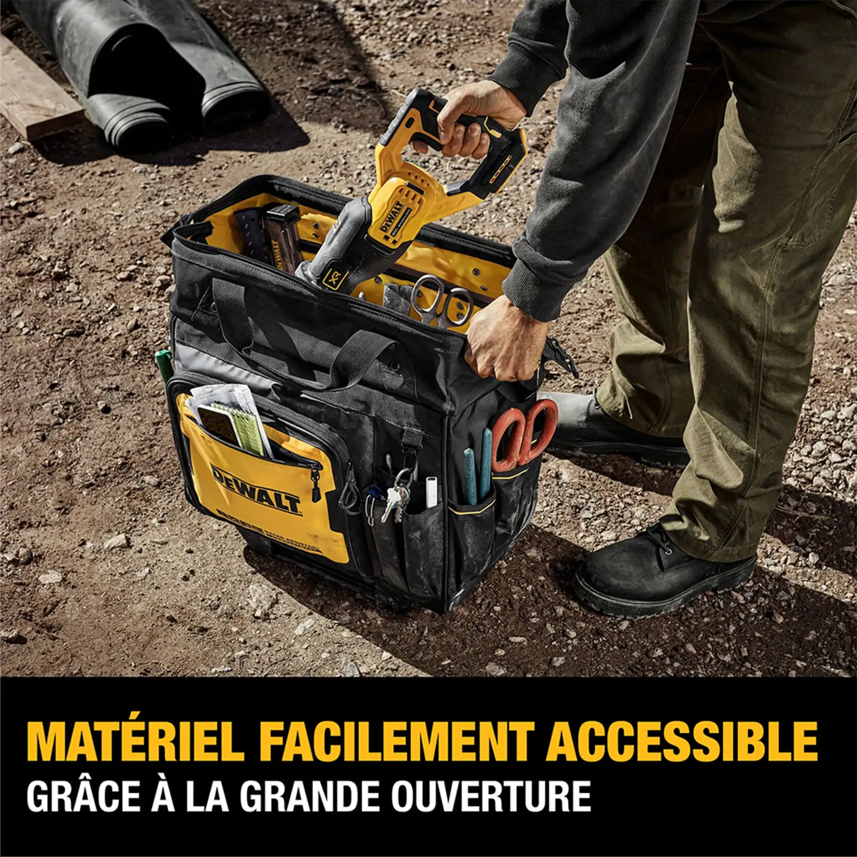 Image showing man placing tool in DeWalt 18 rolling tool bag on job site