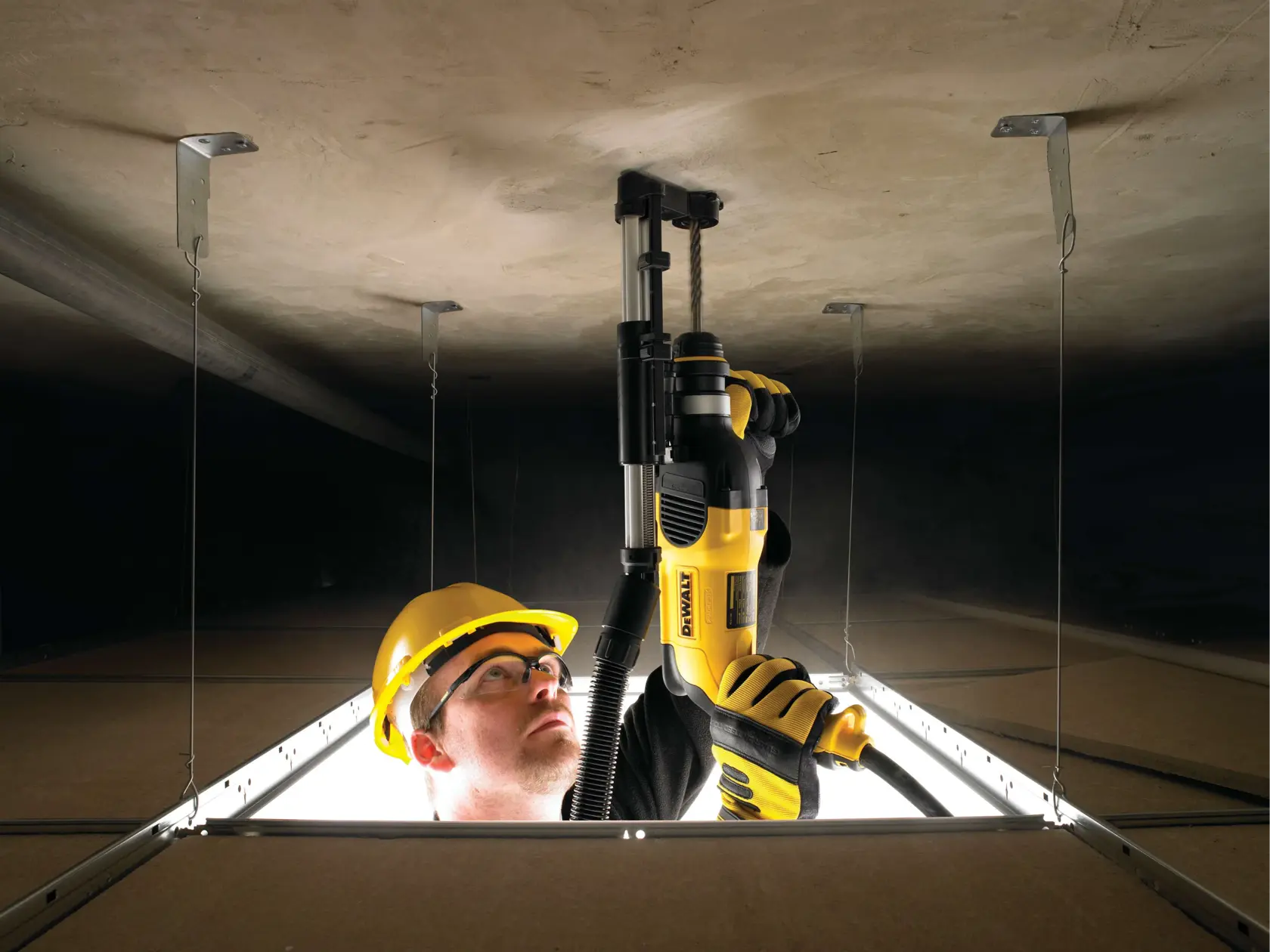Rotary hammer with dust extractor telescope being used by person