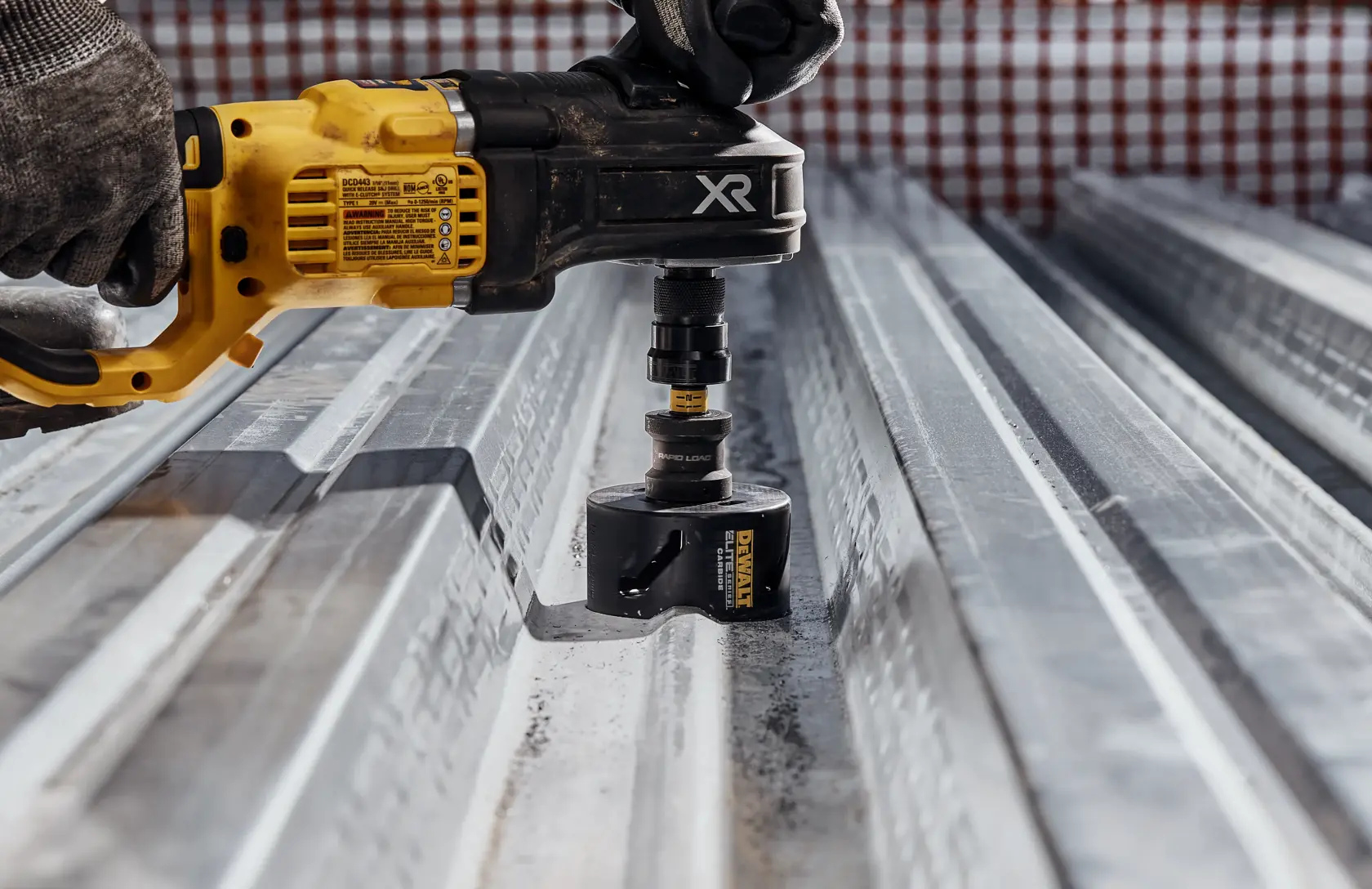 Person using ELITE SERIES Carbide Tipped Holesaw to cut corrogated metal