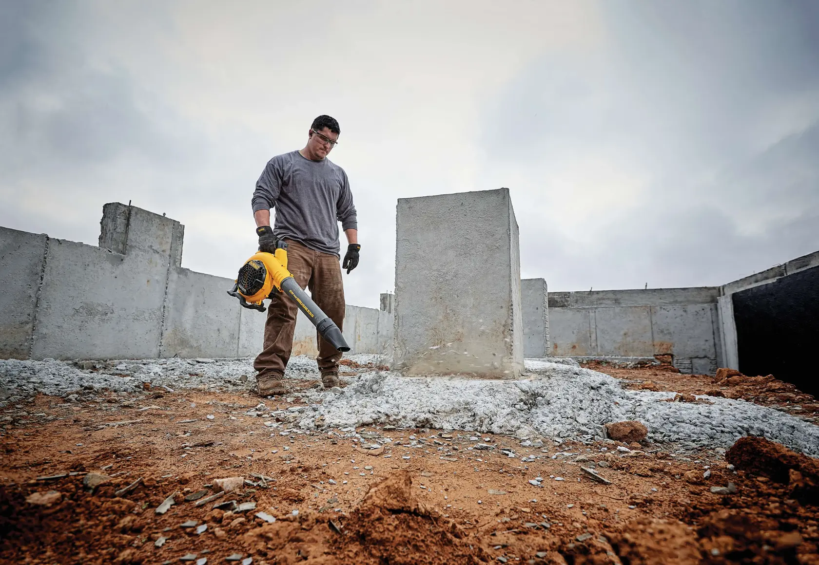 FLEXVOLT Handheld Blower being used by a person to clear site debris on pent roof of a house