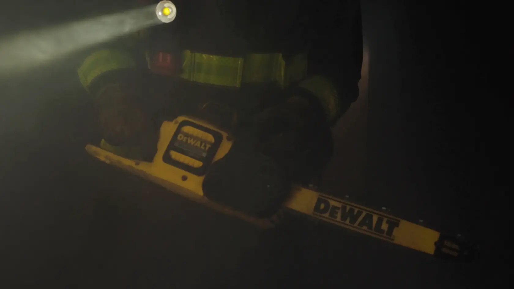Application shot of DeWalt 60V MAX Brushless Chainsaw being held by firefighter