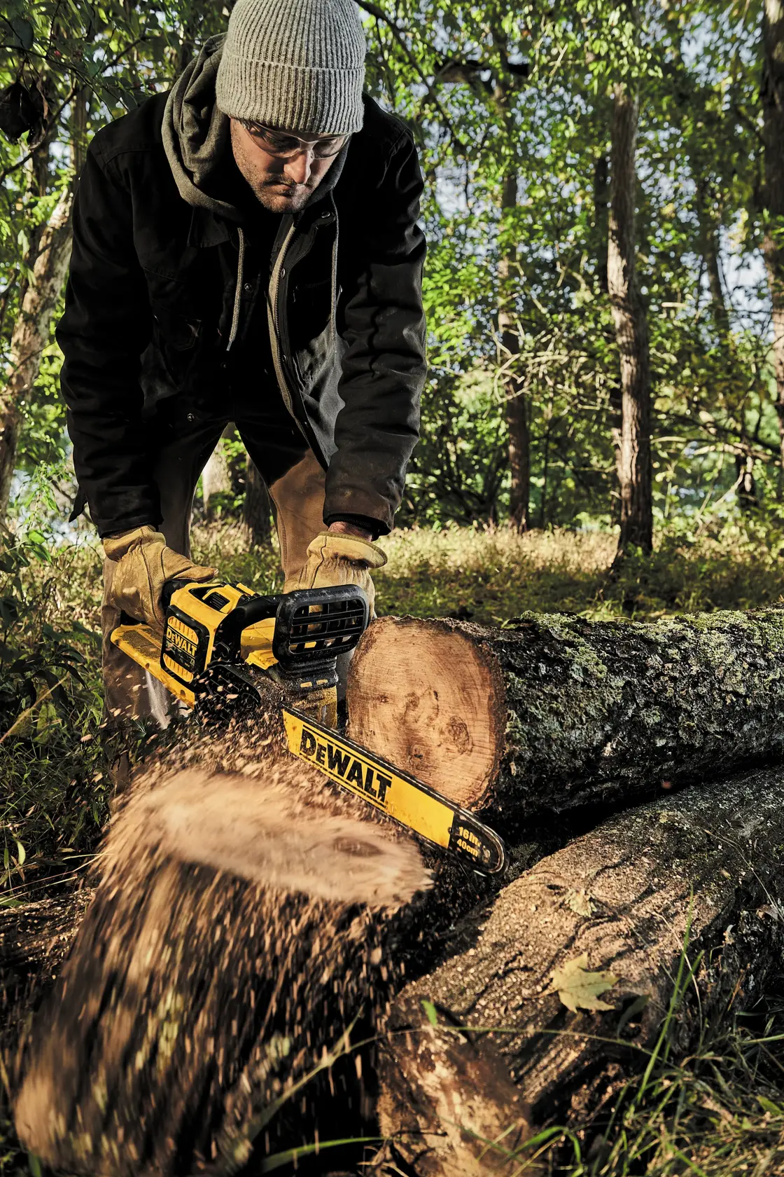 Brushless chainsaw being used to cut a tree by a person.