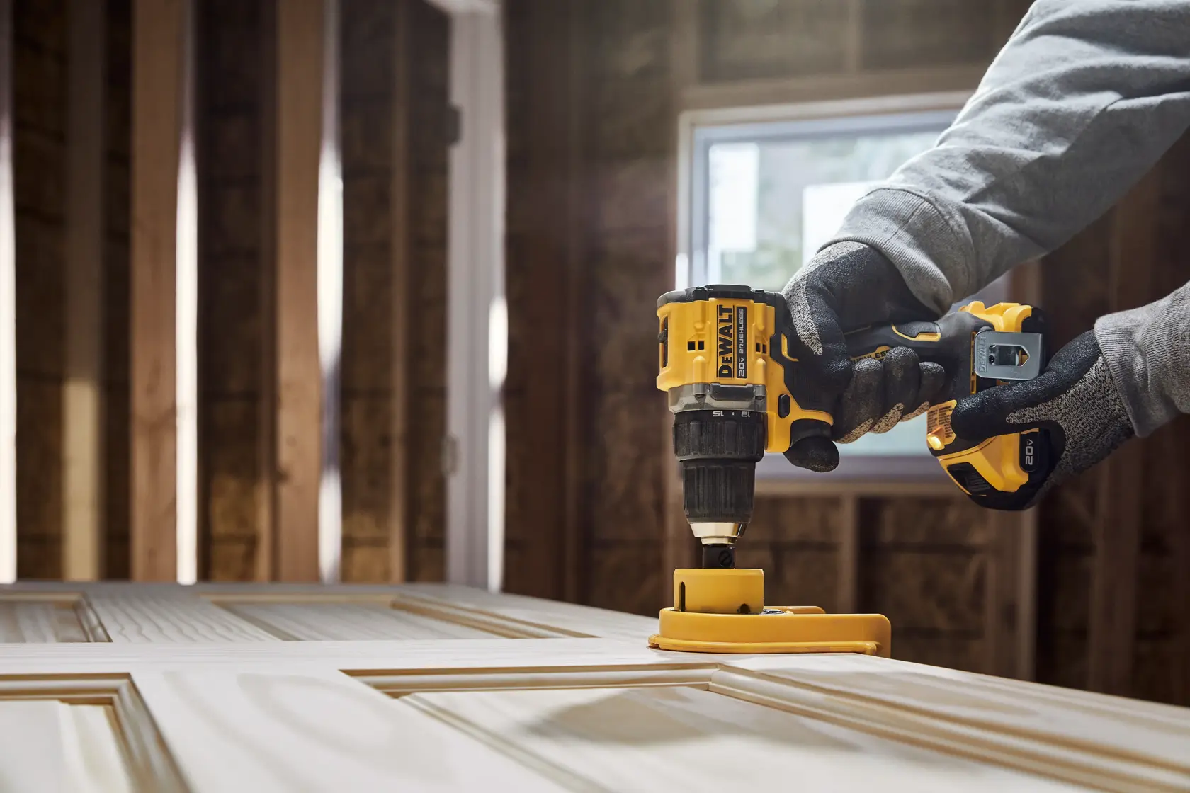 ATOMIC COMPACT SERIES(™)20V MAX Brushless Drill/Driver drilling into a door