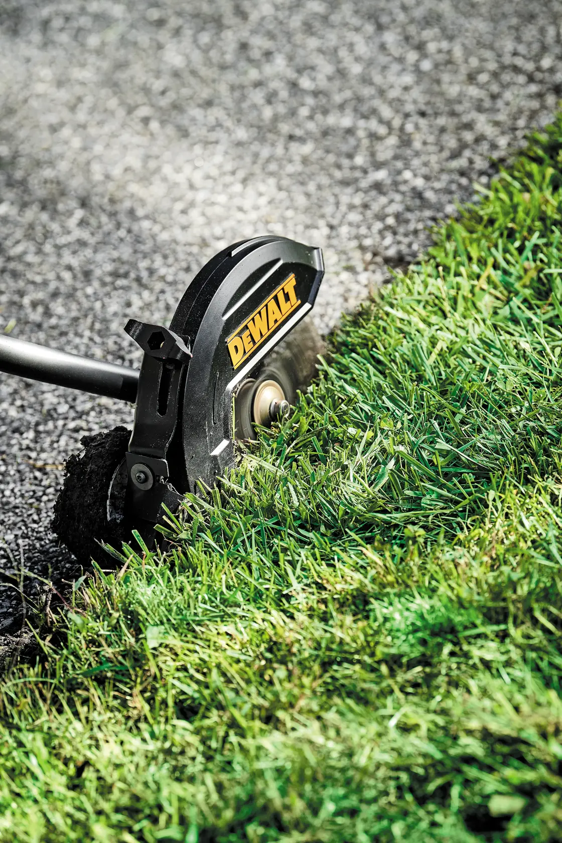Close-up of brushless attachment capable edger kit cutting grass overgrowth.