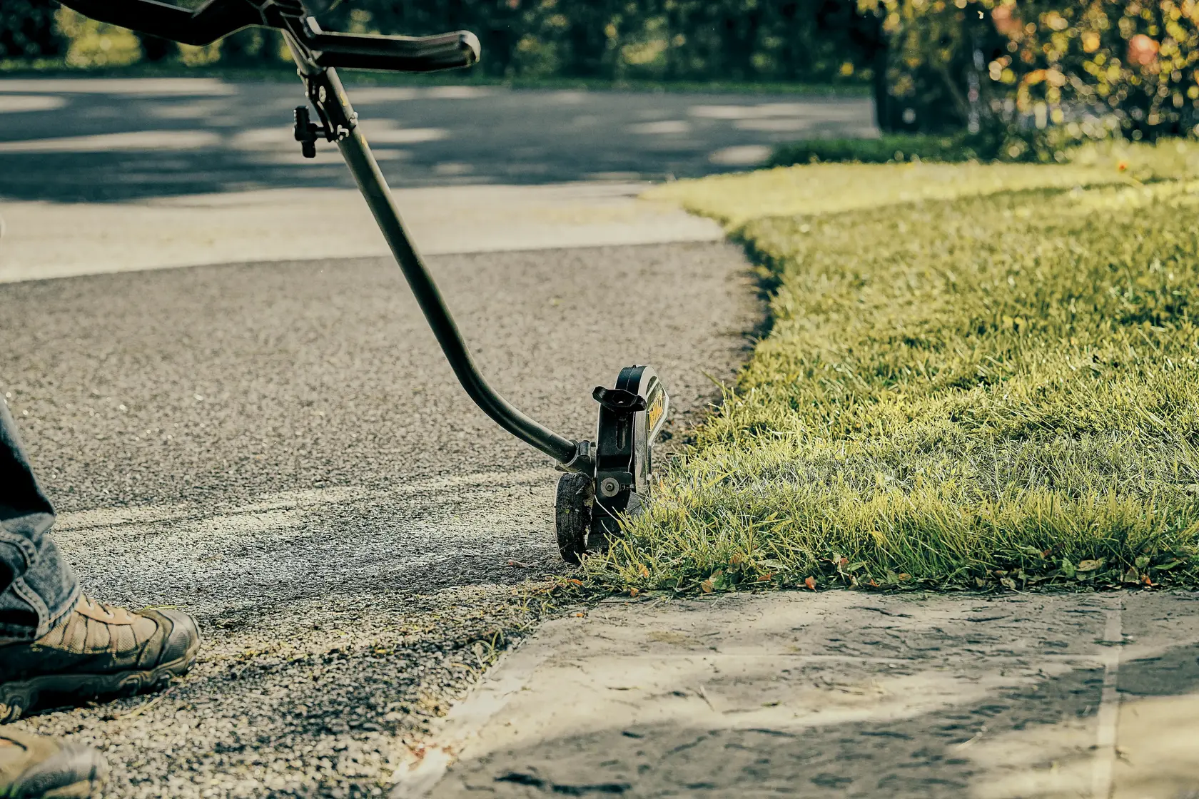 Close-up of brushless attachment capable edger kit cutting grass overgrowth.