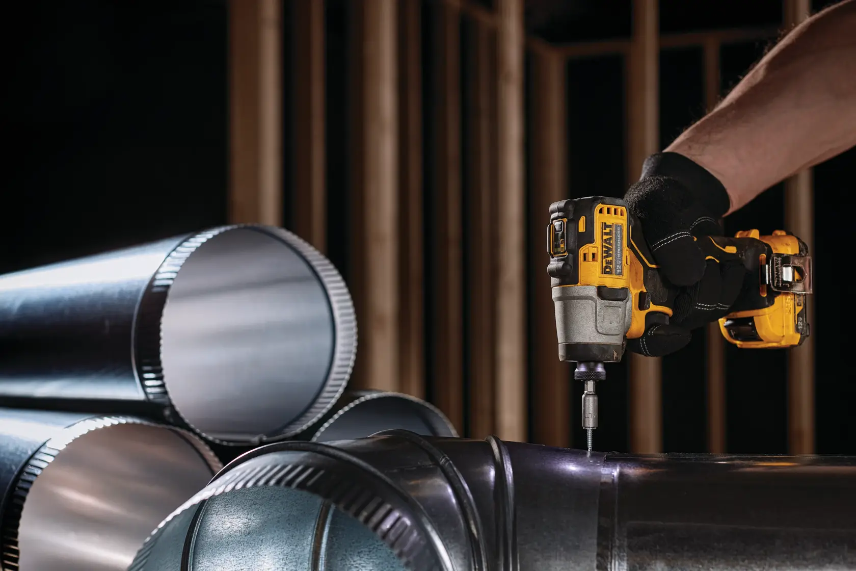 XTREME Brushless cordless impact driver fastening screw in ventilation pipe.