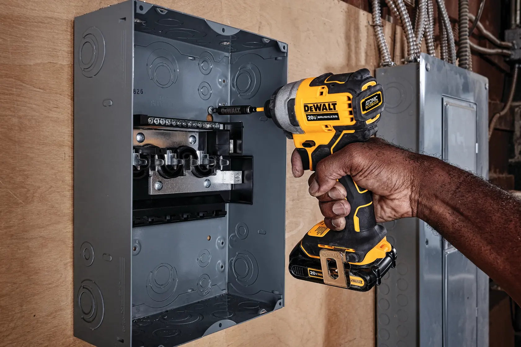 ATOMIC brushless cordless compact impact driver fastening screw through gliding rails on wood.