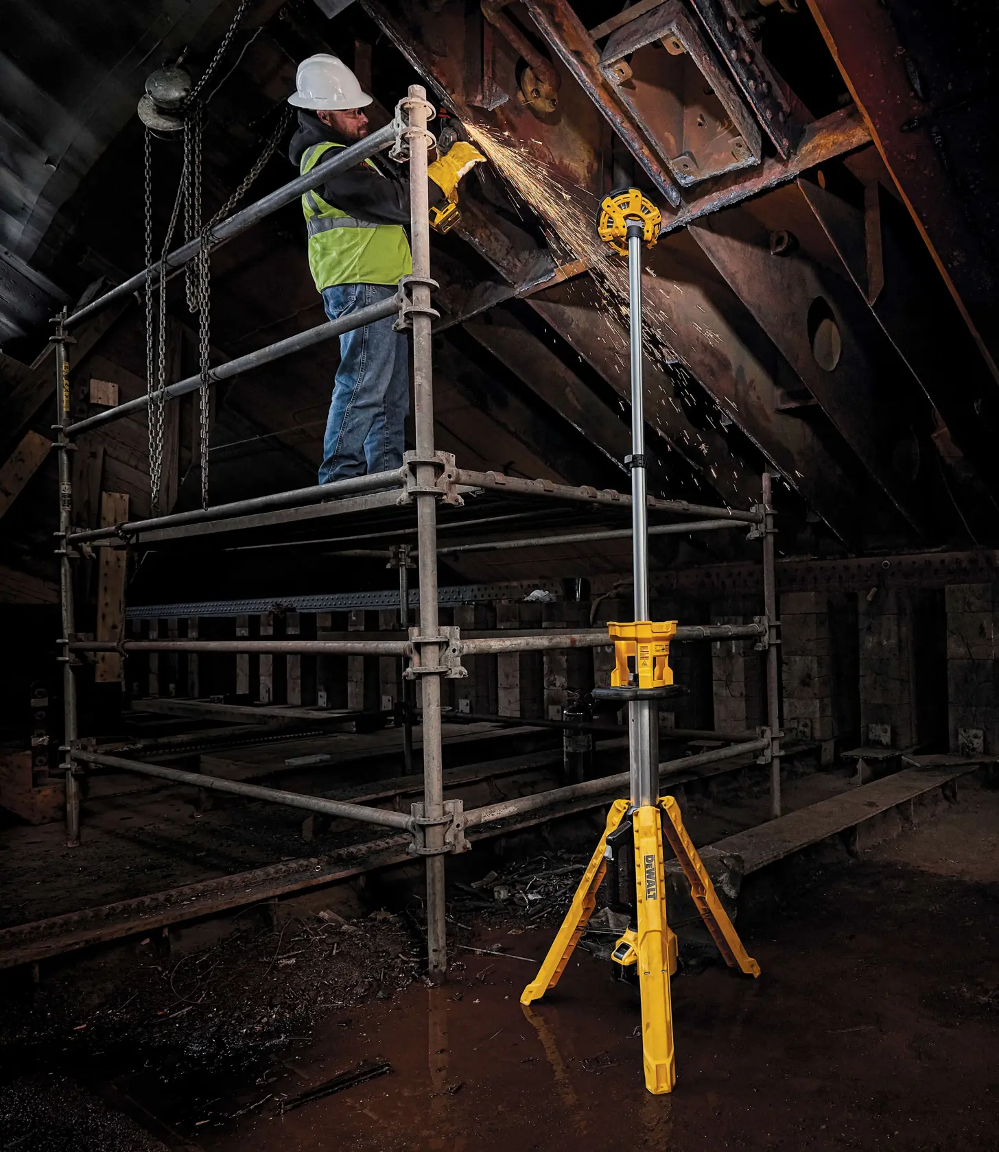 folded cordless tripod light being carried by a person at a construction site