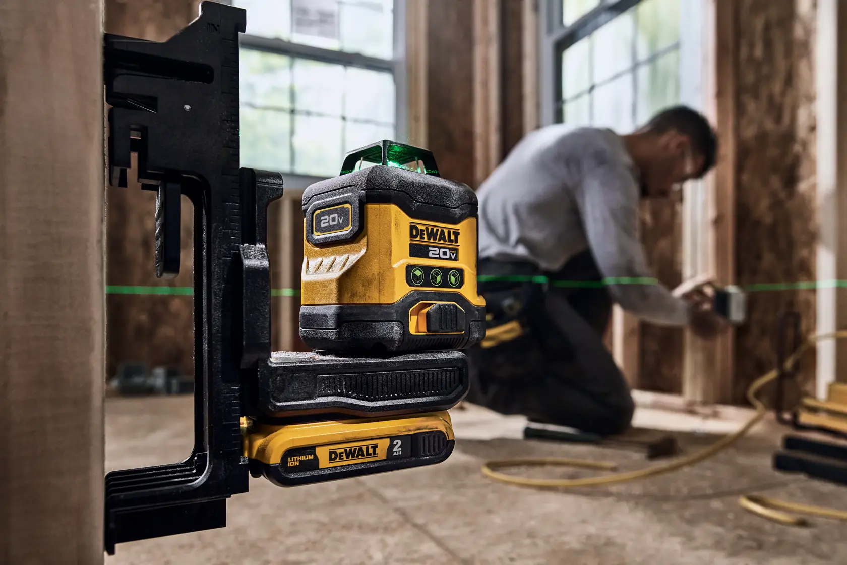 User holding DEWALT 20V MAX Green Line Laser  to mount of magnetized bracket