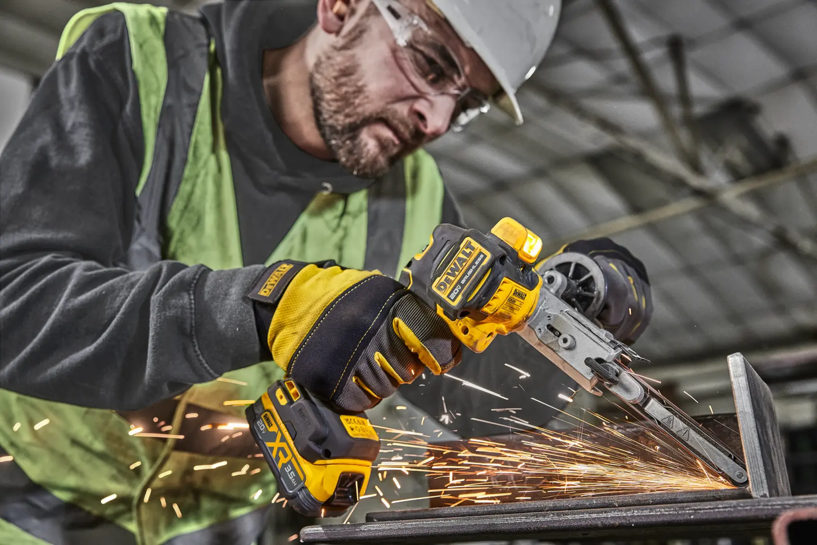 Person using a DEWALT cordless grinder tool, cutting metal with sparks flying in an industrial setting.