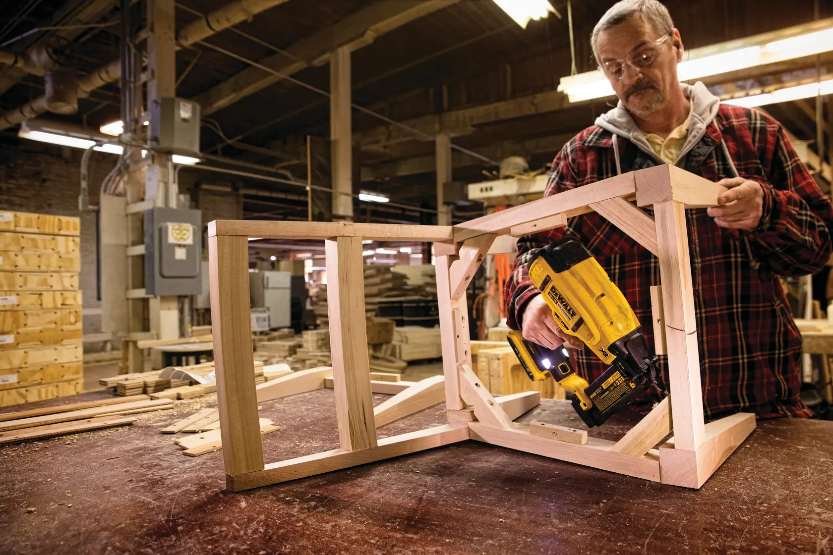 XR 18 GA Cordless Brad Nailer in action on the frame of a wooden chair by a construction worker