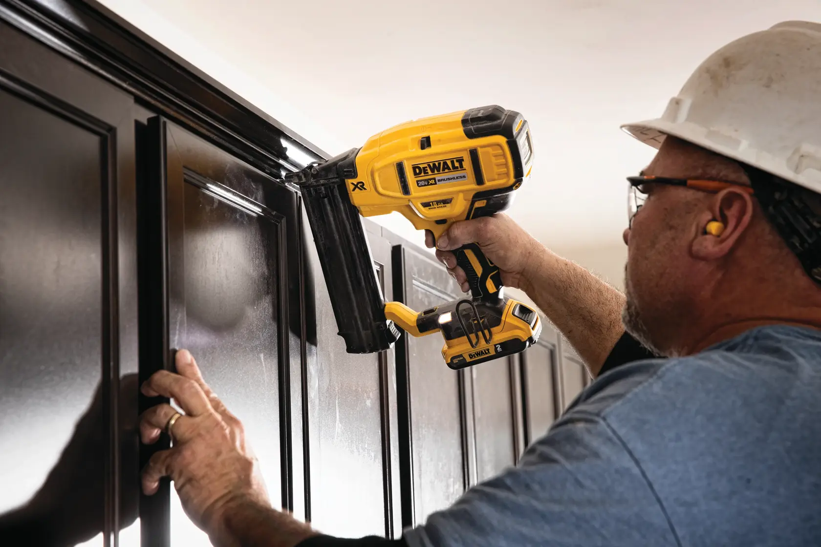 XR 18 GA Cordless Brad Nailer in action on a wooden wall by a construction worker