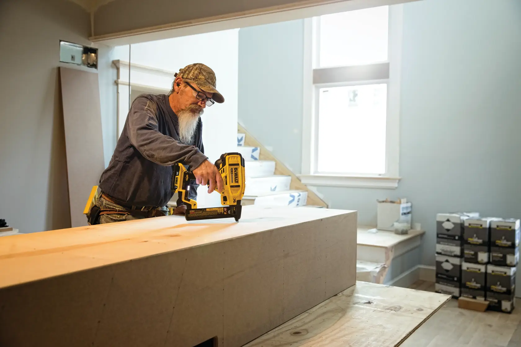 XR 18 GA Cordless Narrow Crown Stapler in action on a wooden board at a worksite