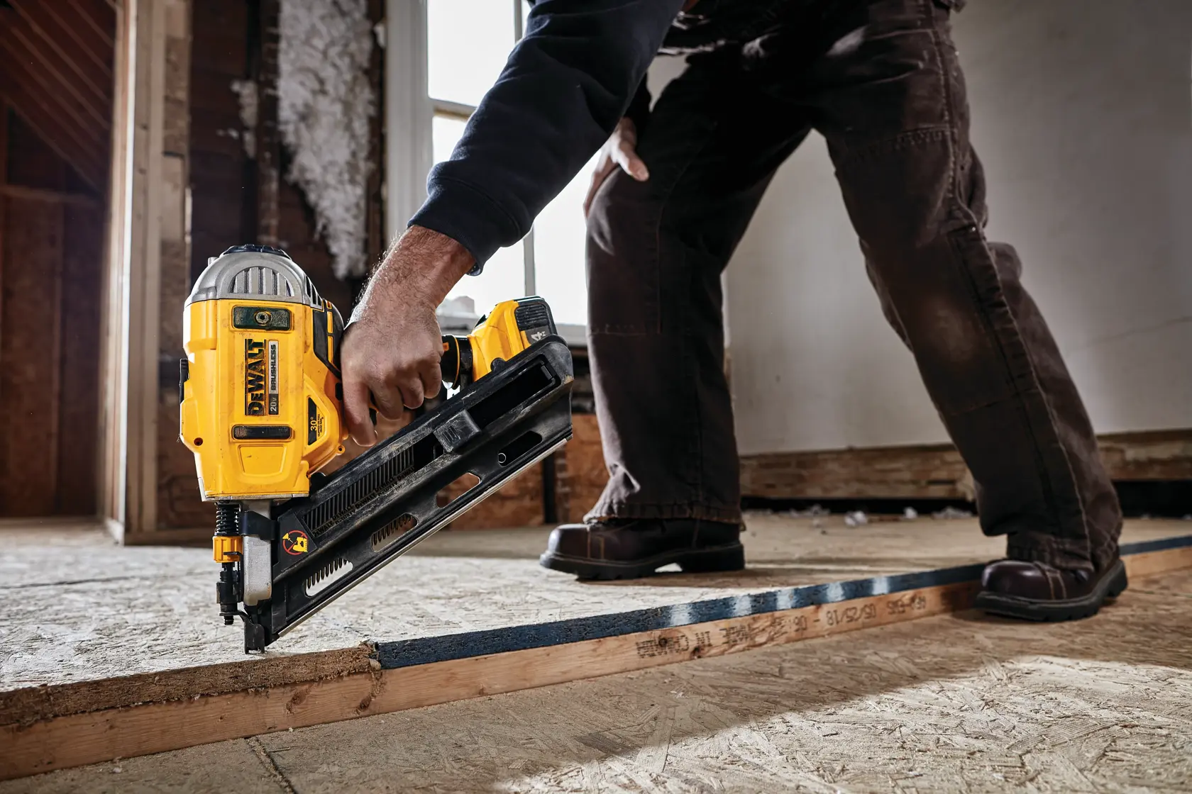 A DEWALT cordless framing nailer in use on a frame