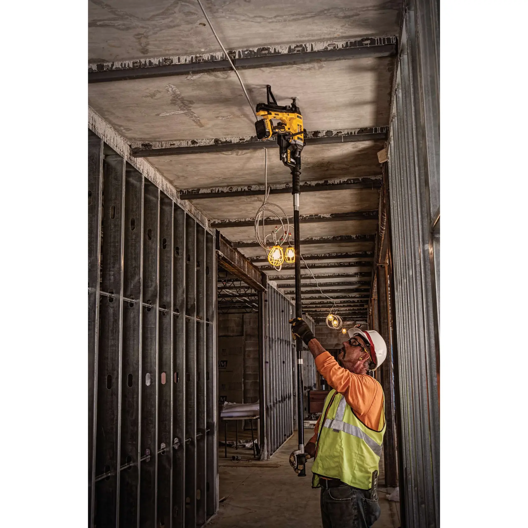 Magazine Cordless Concrete Nailer with a battery being used by a person to sheath to concrete.rn