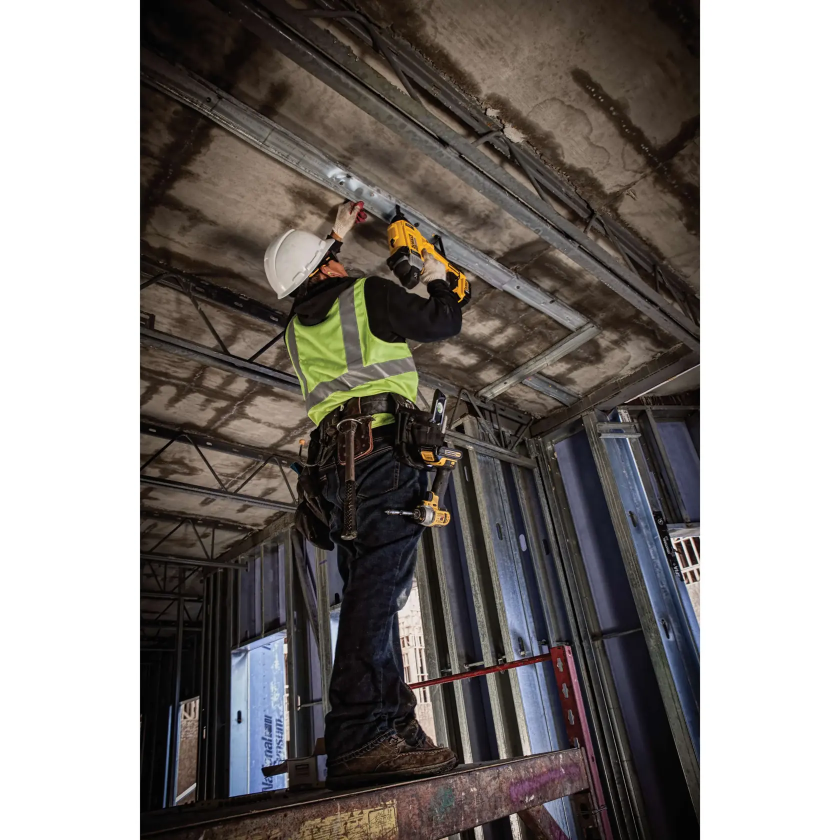 Magazine Cordless Concrete Nailer with a battery being used by a person to install drywall track.rn