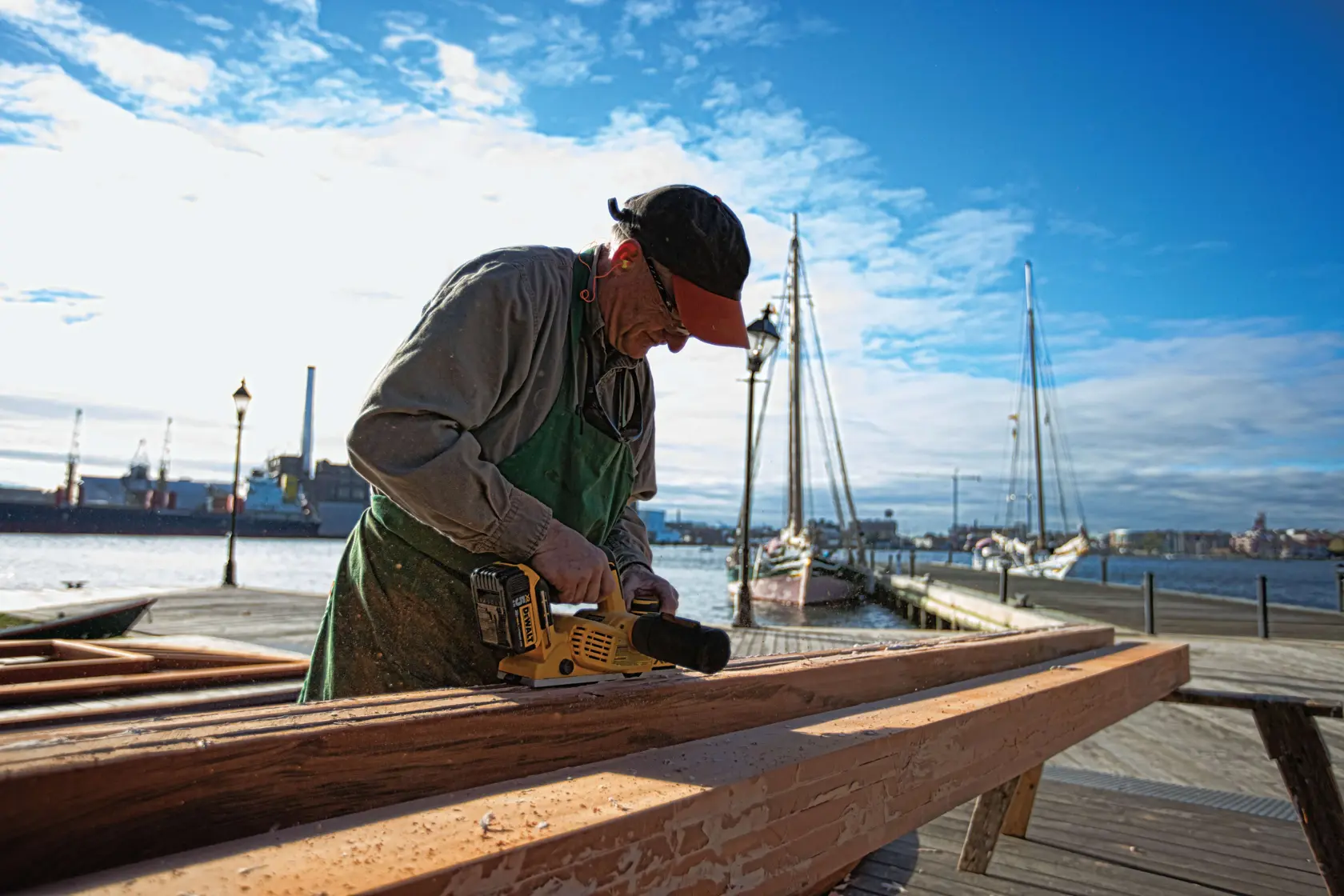   Brushless cordless planer being used by a person to ensure parallelism of cut.rn