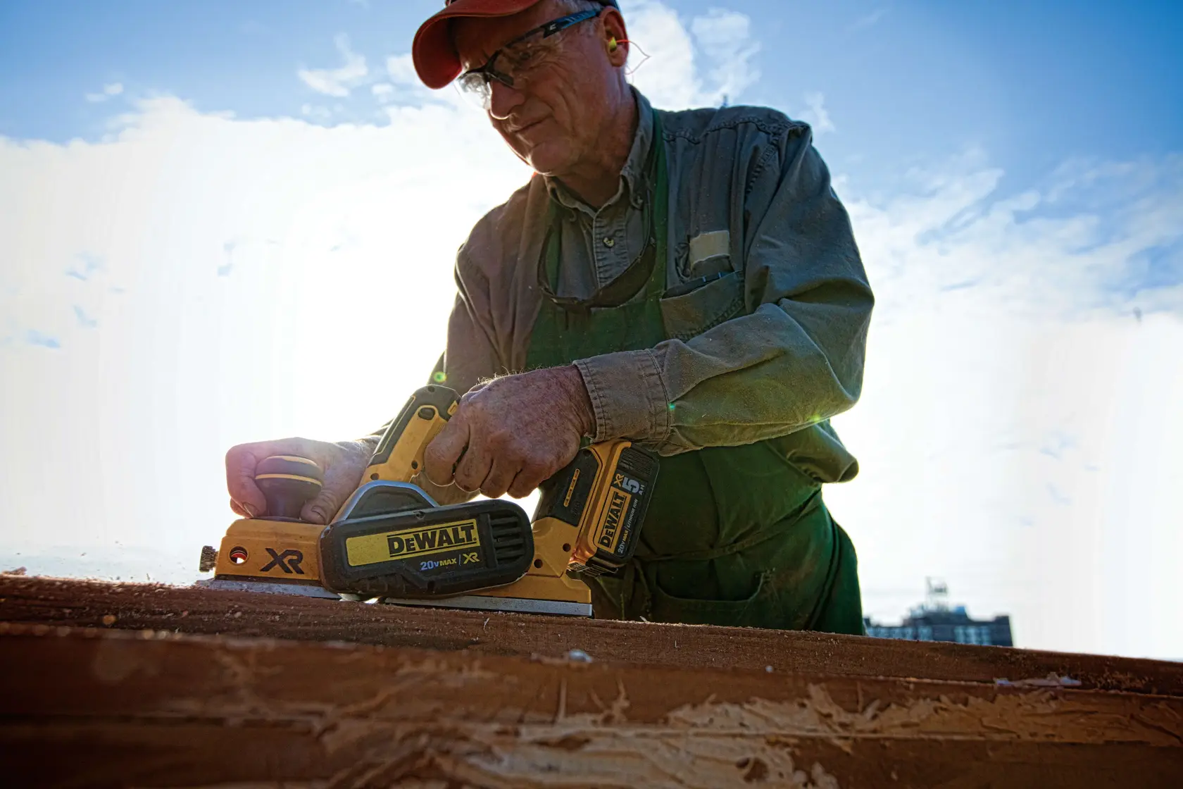 Brushless cordless planer being used by a person to ensure parallelism of cut.rn