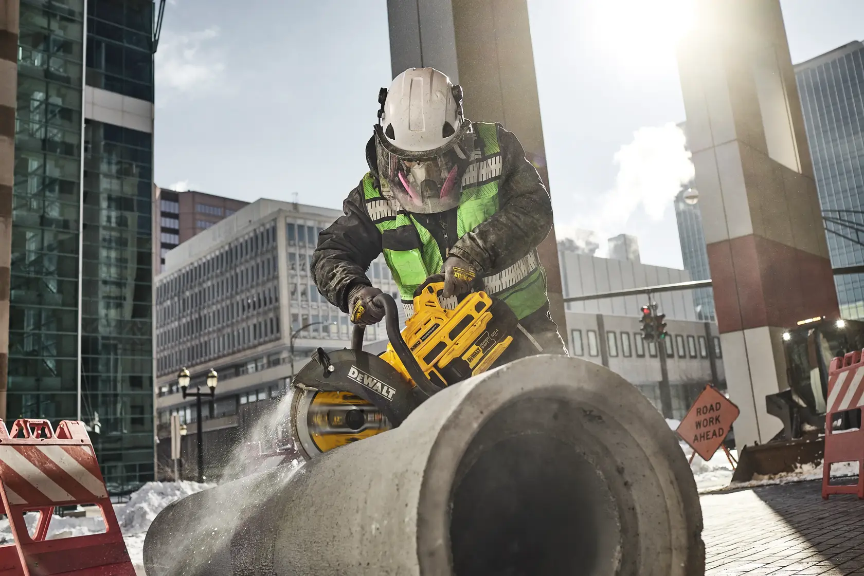 DEWALT DCPS612AG2 and DWA47225 in use cutting concrete on a construction site outdoors.
