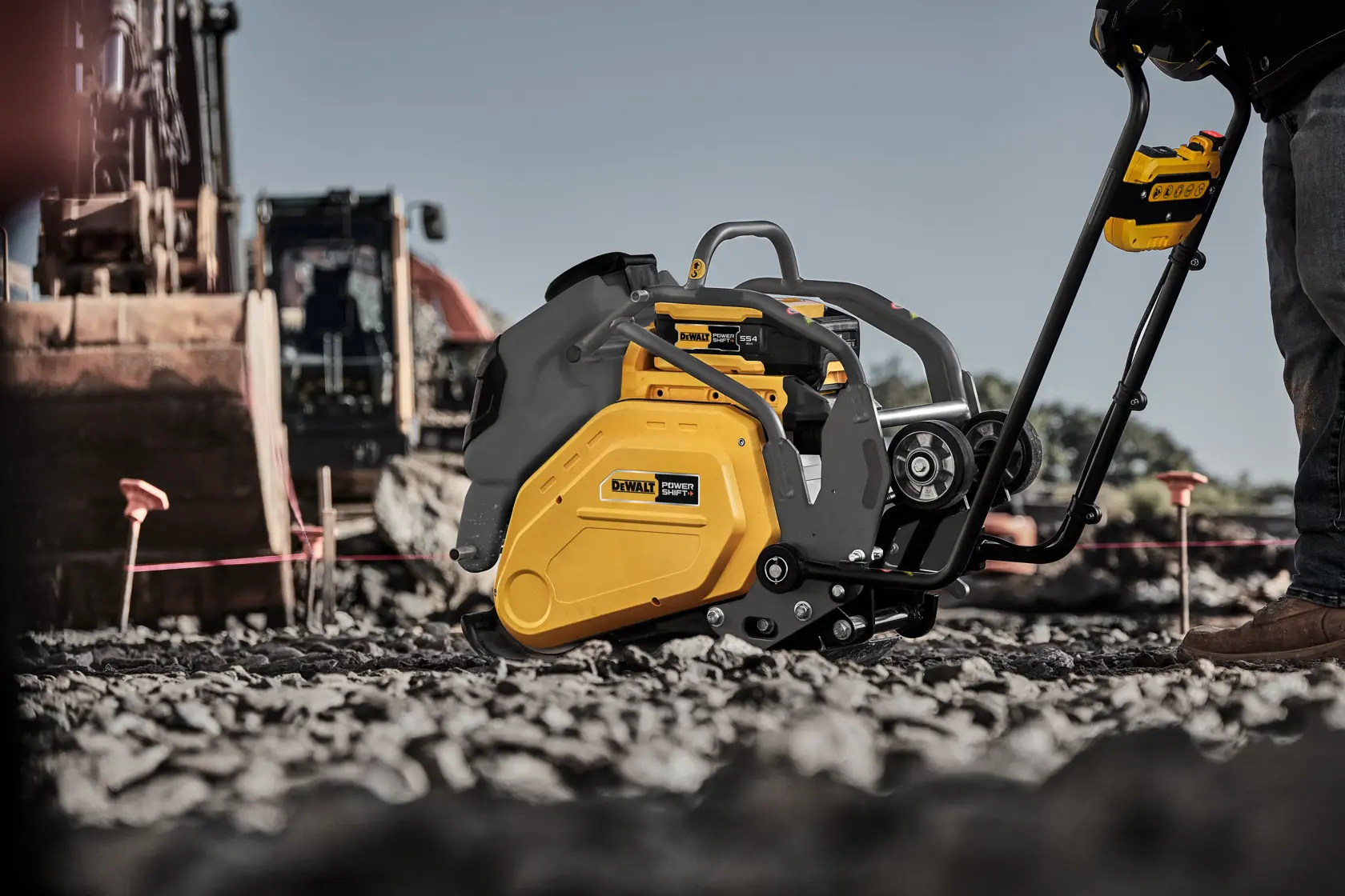 Man running plate compactor