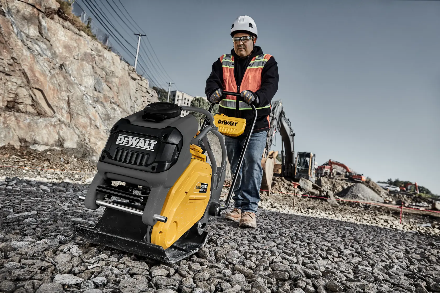 Man running plate compactor