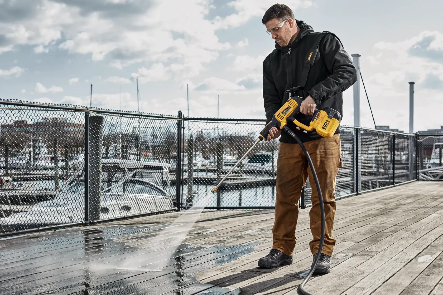 User cleaning wooden deck with DEWALT 60V Power Cleaner