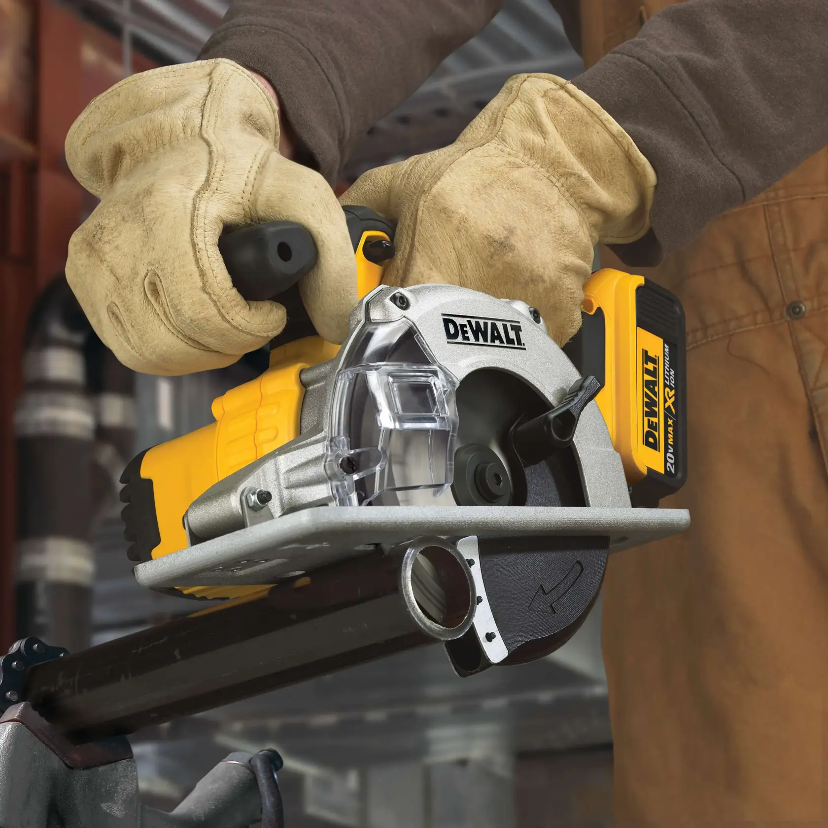 A person wearing work gloves operates a DEWALT cordless circular saw, cutting through a metal pipe in an industrial setting.