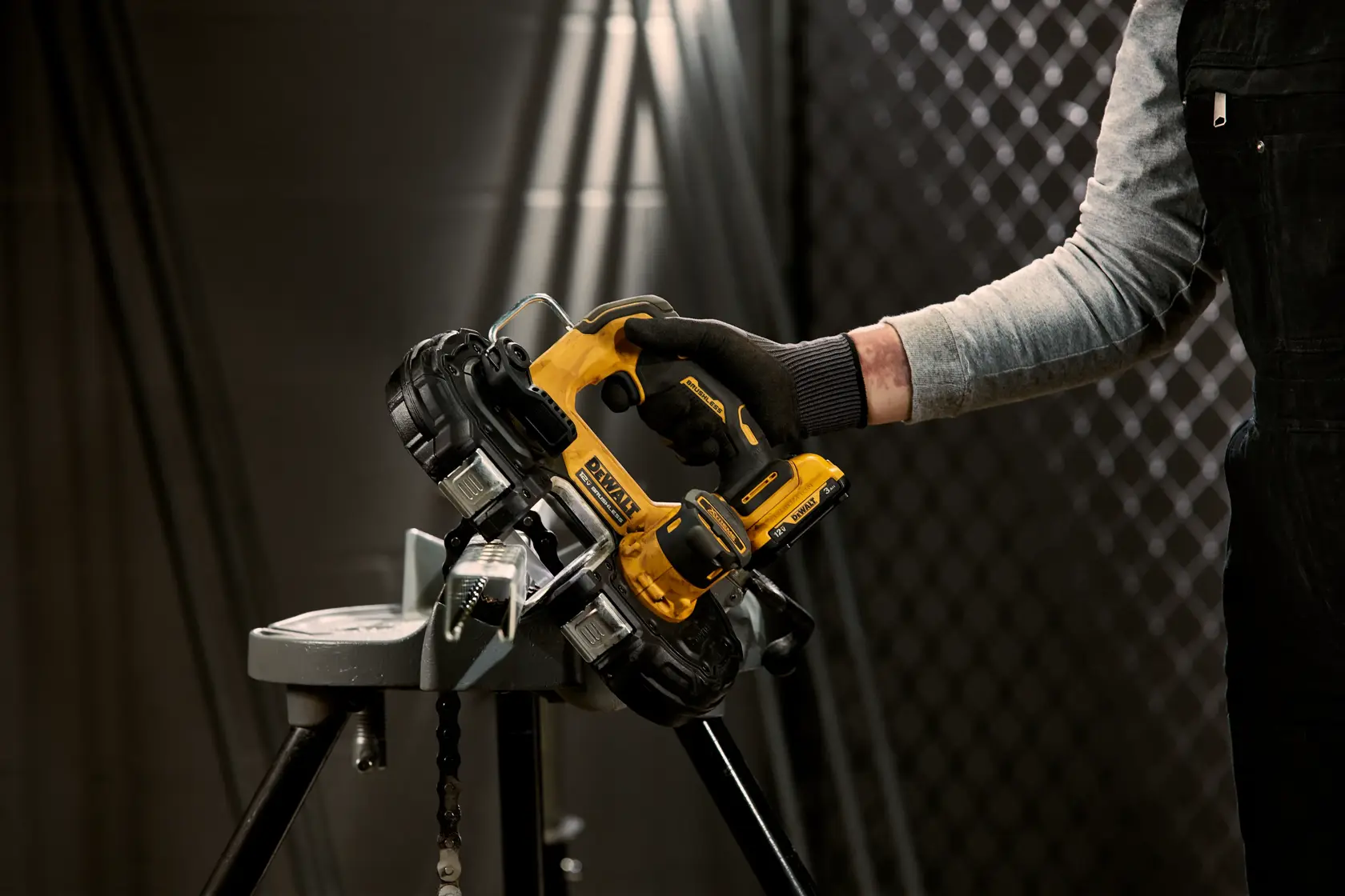 Xtreme 12 volt 1 and three quarter inch brushless cordless band saw tool being used to cut metal.