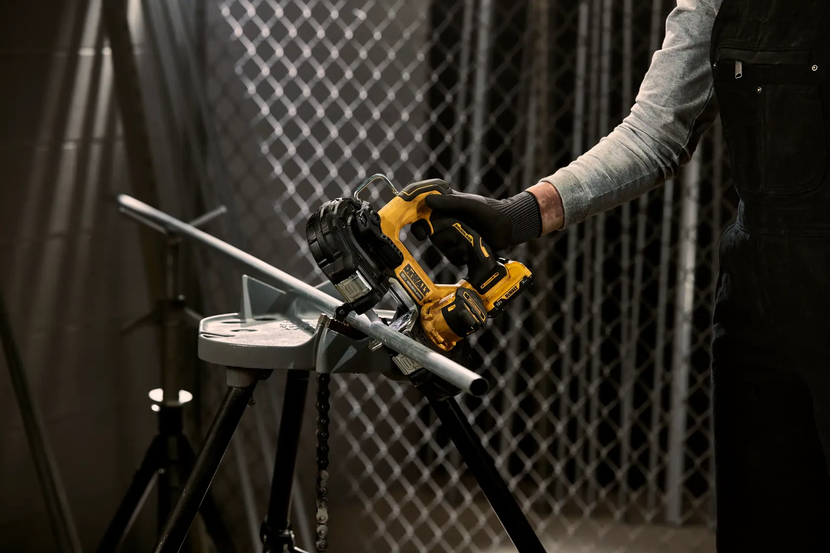 Xtreme 12 volt 1 and three quarter inch brushless cordless band saw tool being used to cut metal.