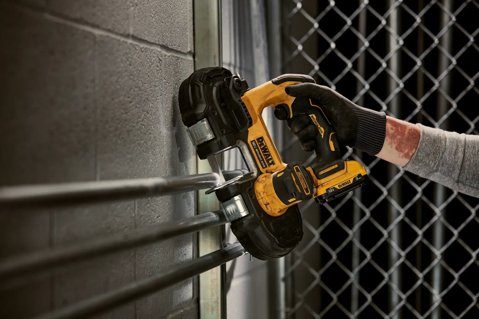 Xtreme 12 volt 1 and three quarter inch brushless cordless band saw tool being used to cut metal.