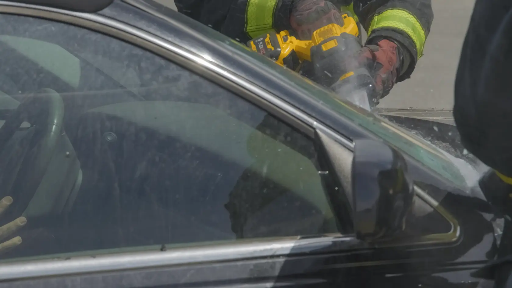 Application shot of DeWalt 60V Max Cordless Brushless Reciprocating Saw being used to saw into car windshield