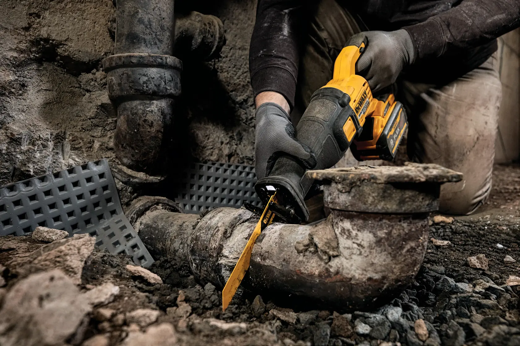 FLEXVOLT brushless cordless reciprocating saw being used to cut drainage pipe.
