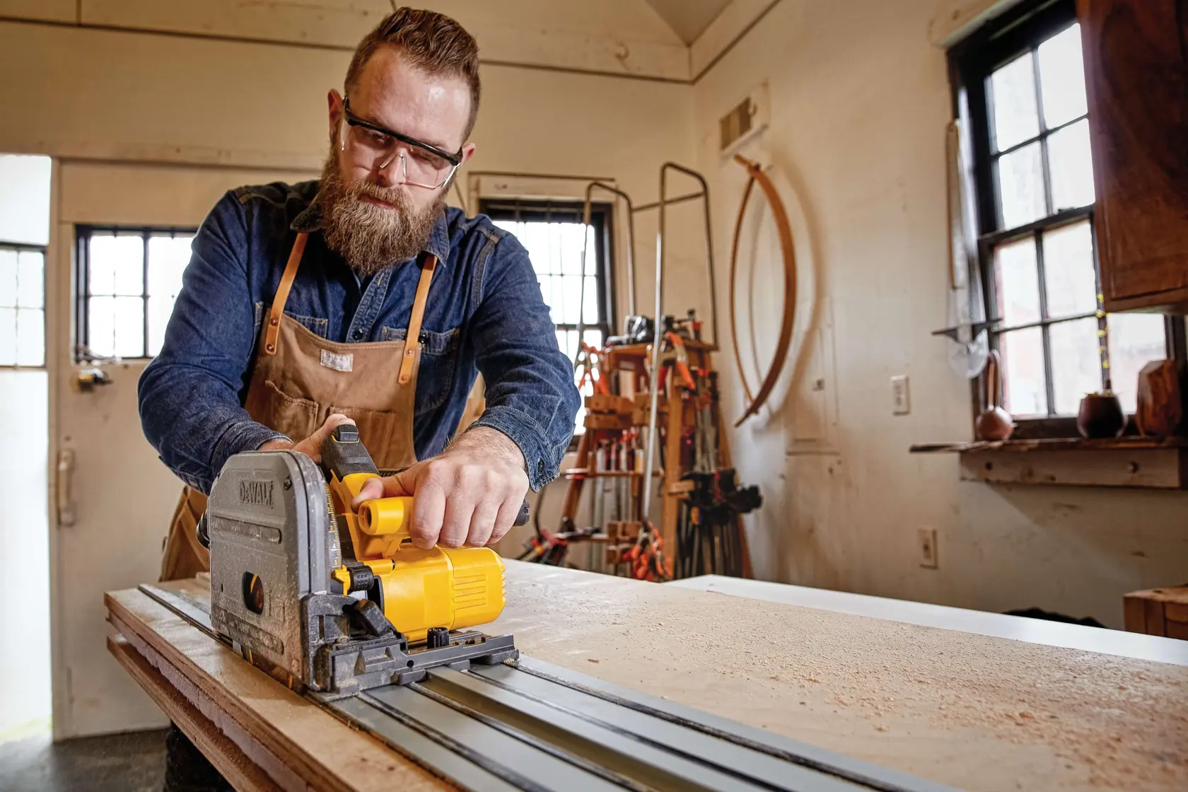 Brushless TRACK SAW kit powered by FLEXVOLT being used by person to cut wooden plank.