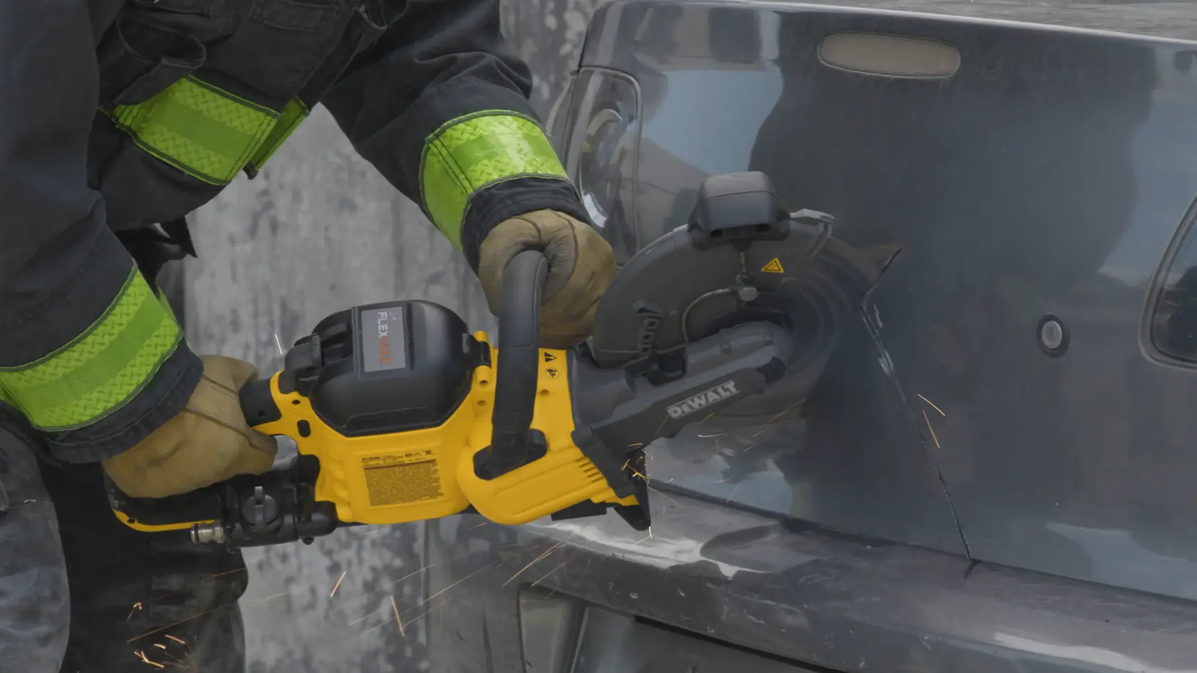Application shot of DeWalt 60V Max 9 In Cut off Saw being used by fire fighter to cut open car trunk