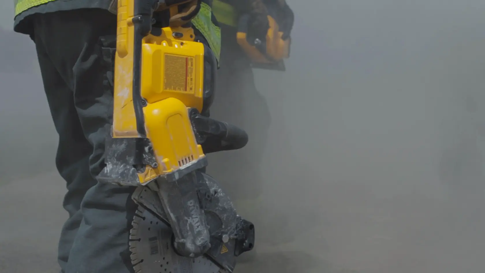 Application shot of DeWalt 60V Max 9 In Cut off Saw being held by fire fighter