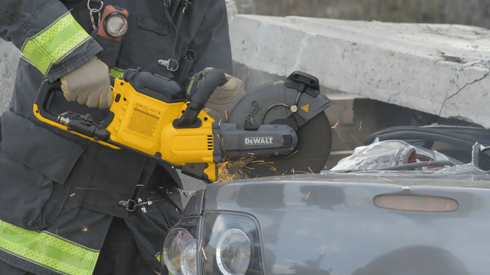 Application shot of DeWalt 60V Max 9 In Cut off Saw being used by fire fighter to cut open car trunk