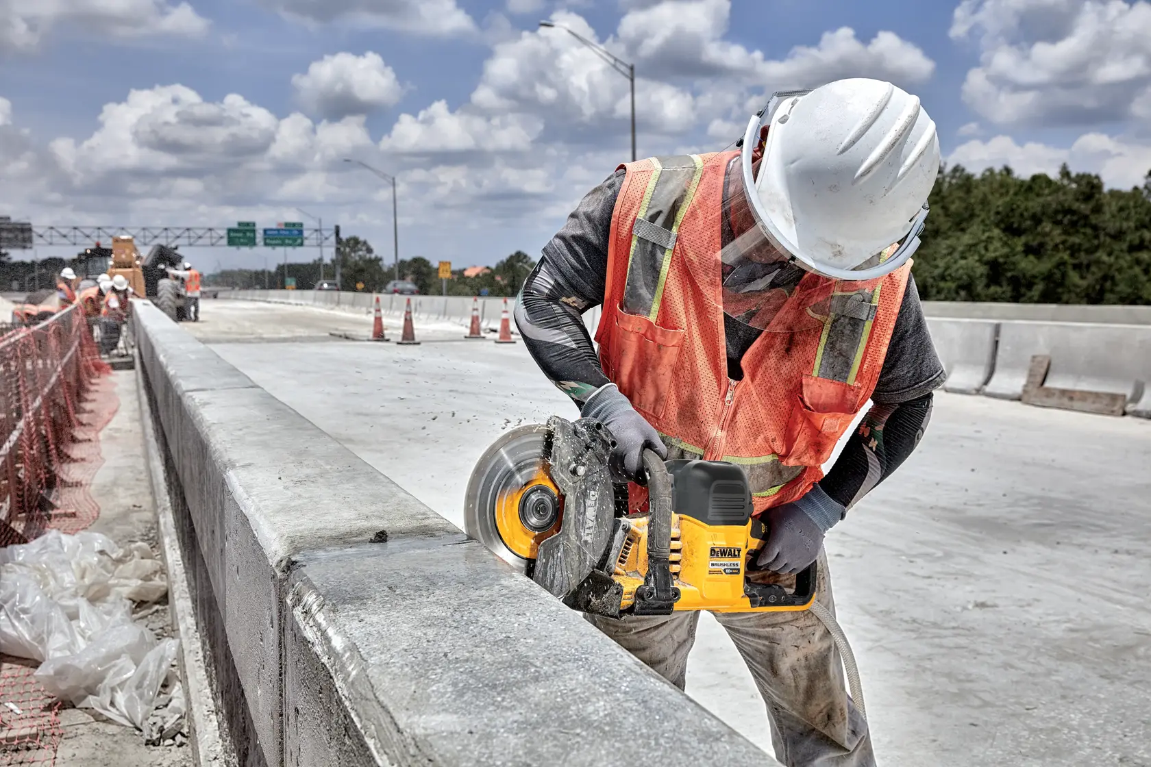 Application image of DEWALT DCS692 cutting into concrete barrier