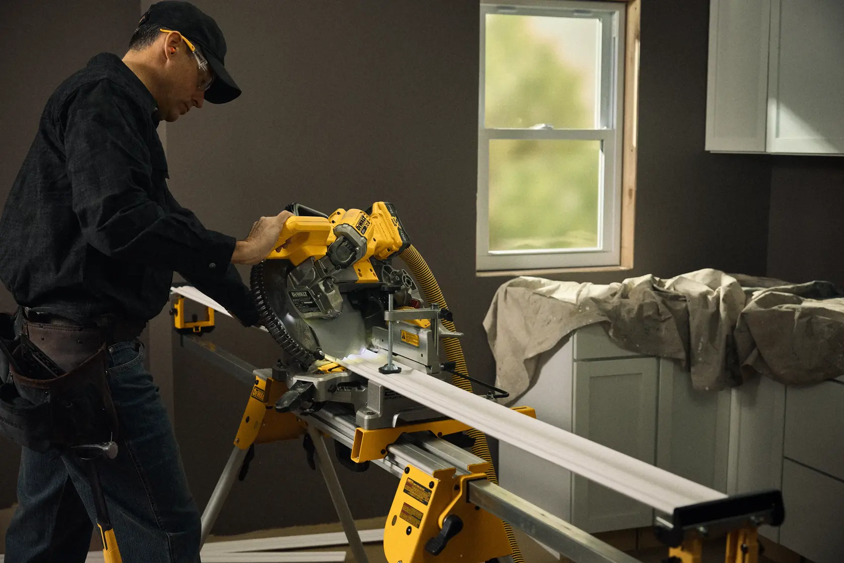 Talent cutting a piece of material with the 20V MAX* XR® 10in. Double Bevel Sliding Miter Saw 