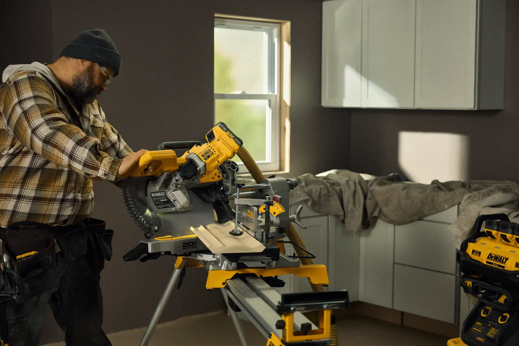 Talent cutting a piece of material with the 20V MAX* XR® 12in. Double Bevel Sliding Miter Saw Kit in a residential environment