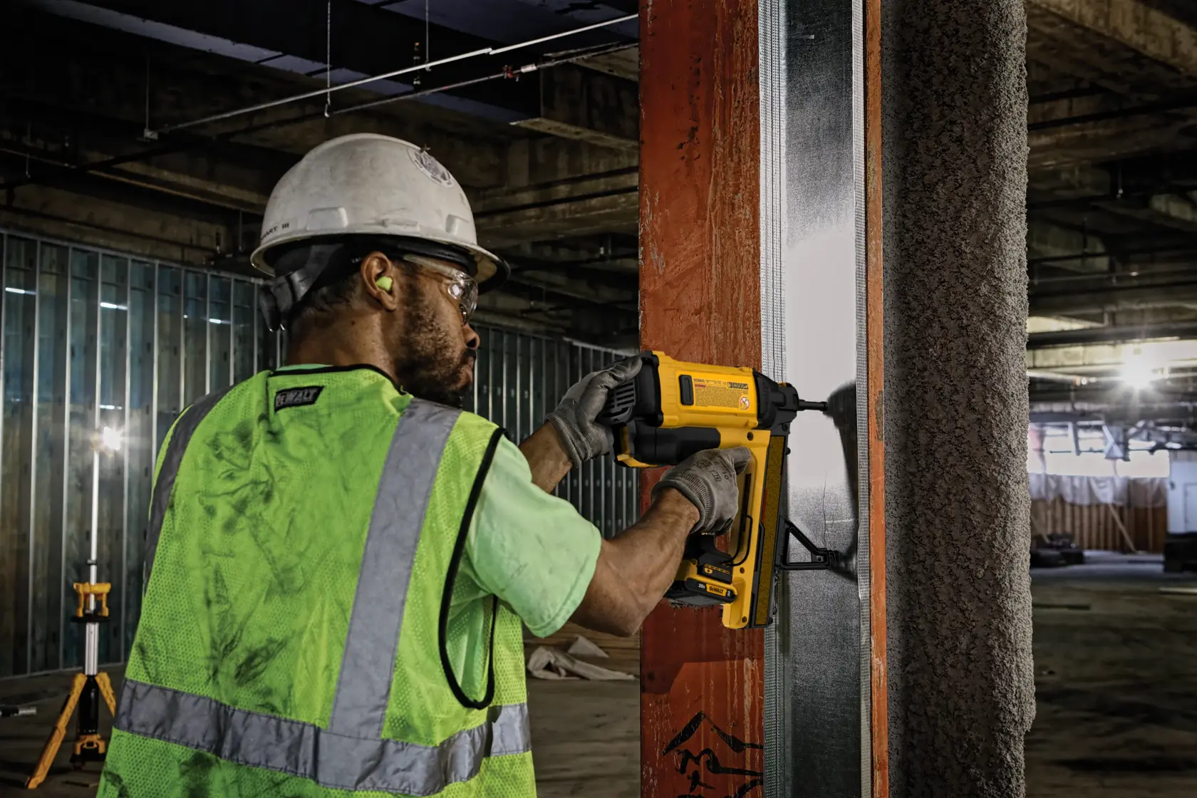 Worker uses DEWALT tool DGN845D1-QW, DGN845D1 for fastening in construction. Product category: Photography.