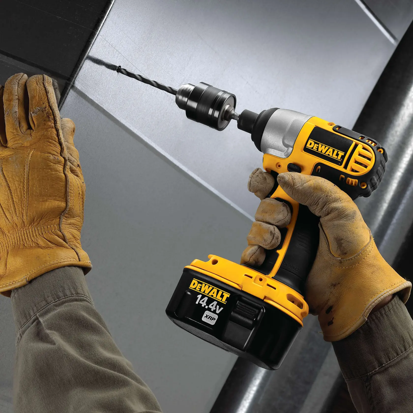 A gloved person uses a DEWALT 14.4V cordless drill to drill into a metal surface.