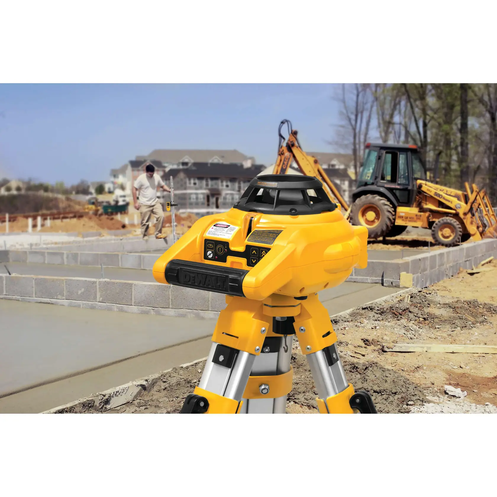 Interior and exterior rotary laser level kit mounted on a tripod at a construction site.