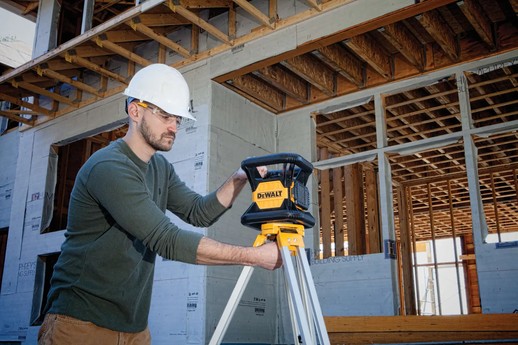 Green rotary tough laser being set up by a person.